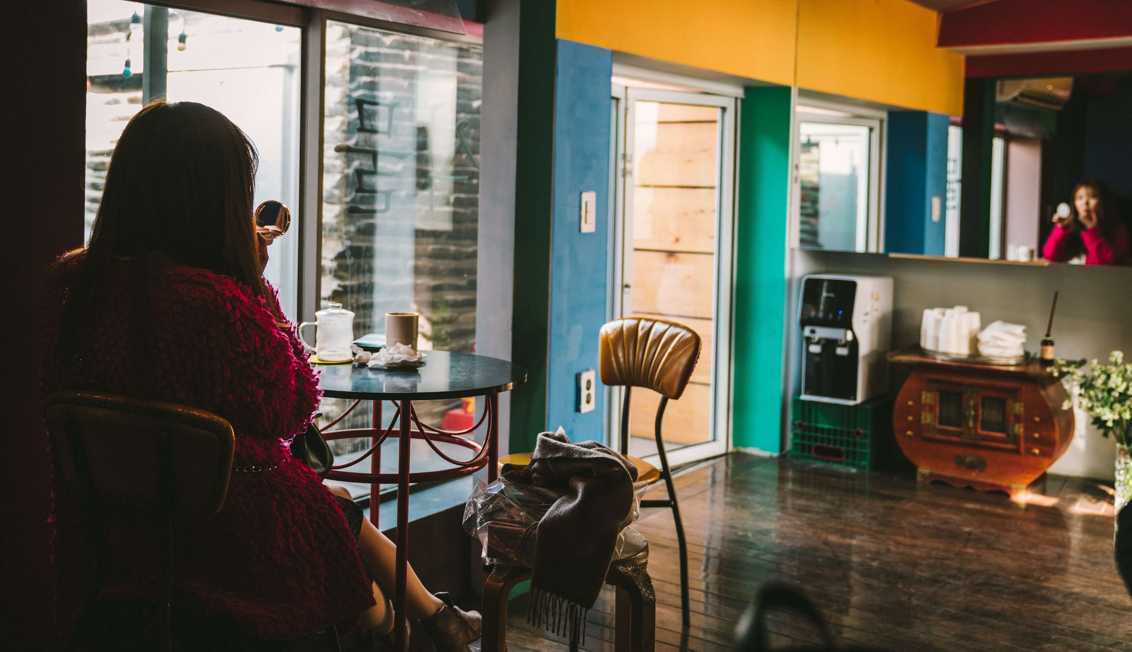 Woman in a cafe fixing her makeup