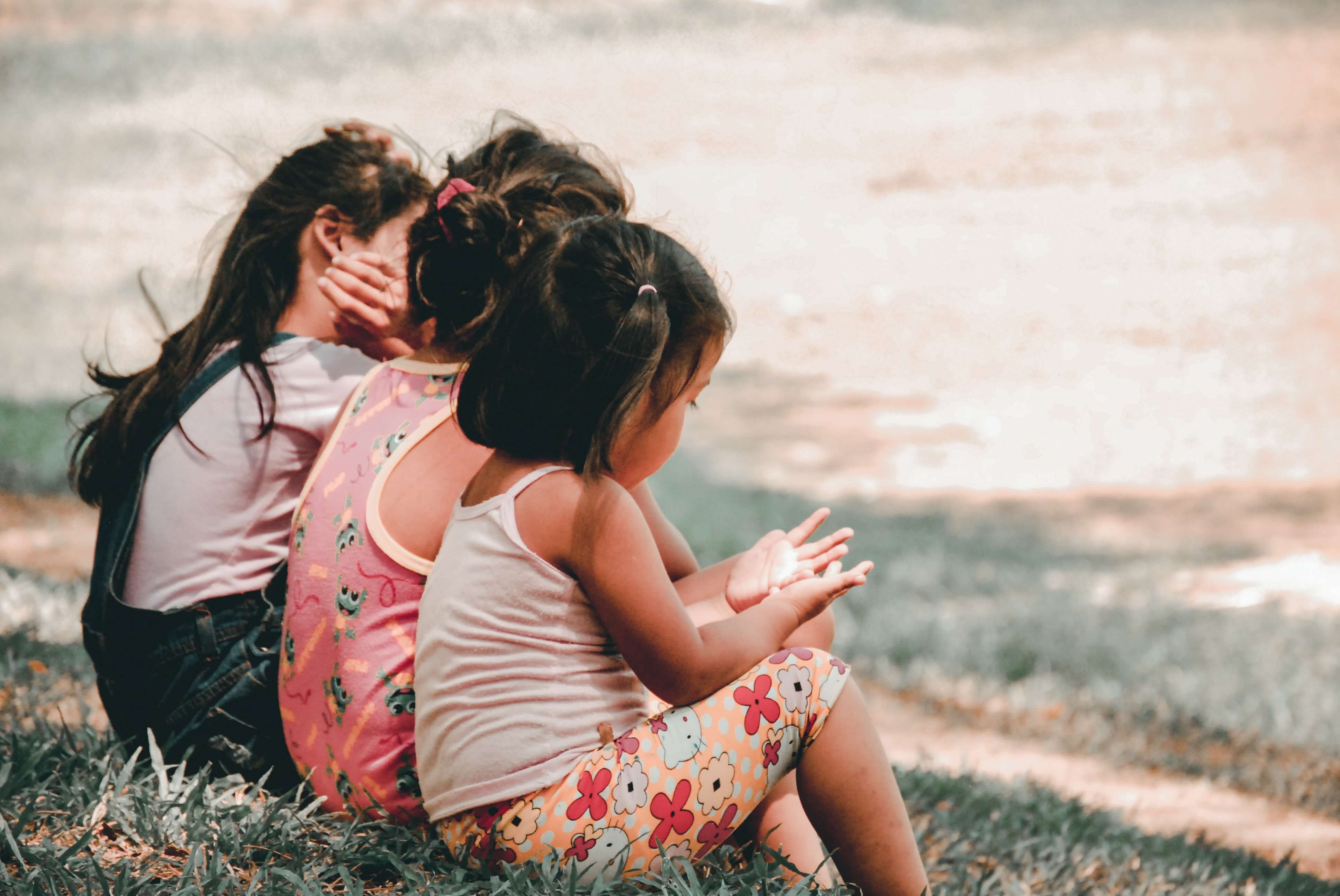 3 Little girls sitting down on grass
